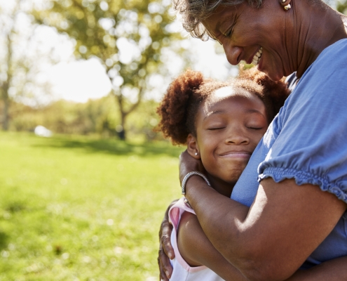 Close Up Of Granddaughter Hugging Grandmother In Park