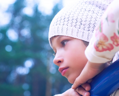 Little Caucasian child girl looking seriously being on the playground.
