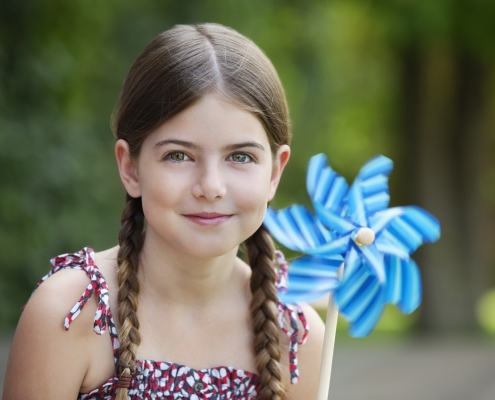 Smiling girl holding pinwheel outdoors