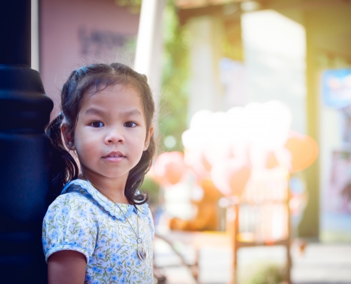 Asian little girl standing and looking in park